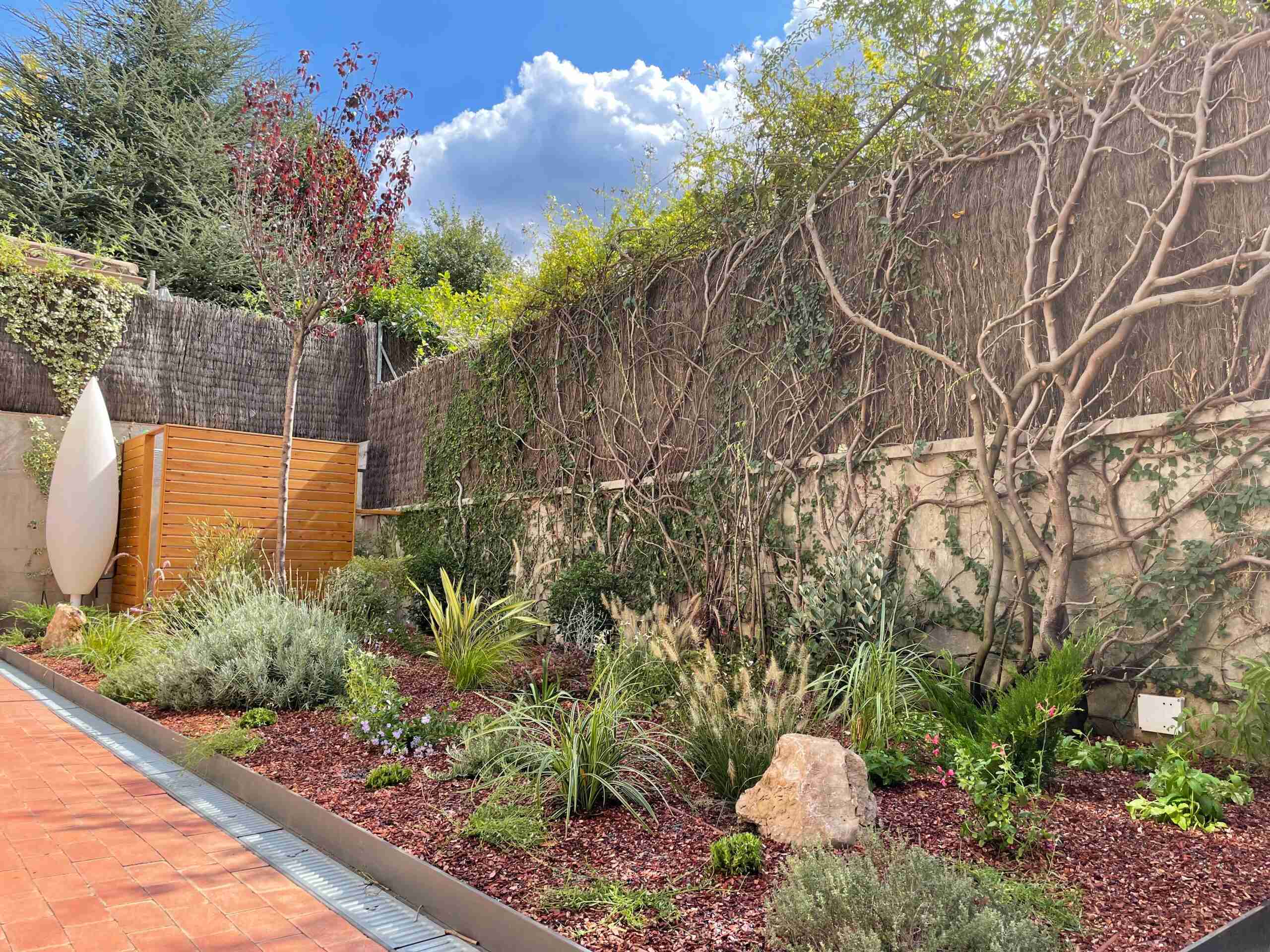 Jardín de bajo mantenimiento con grava, arbustos mediterráneos y riego por goteo, diseñado para requerir poco trabajo durante todo el año.