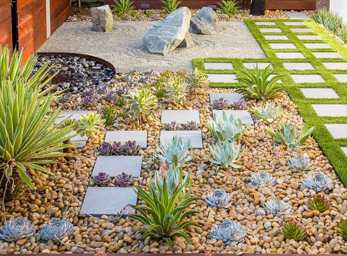 Jardín sostenible con plantas autóctonas, riego por goteo, acolchados orgánicos y zonas de biodiversidad que muestran un espacio verde de baja huella ecológica.